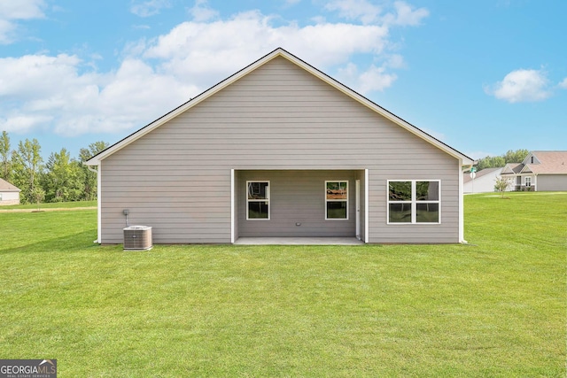 back of property with a lawn, a patio area, and cooling unit