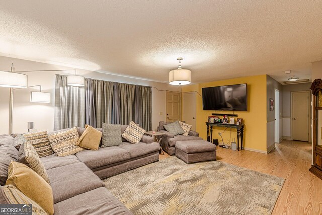 146 Highland Cir, Mcdonough, GA 30253 - living room featuring light wood finished floors, a textured ceiling, and baseboards