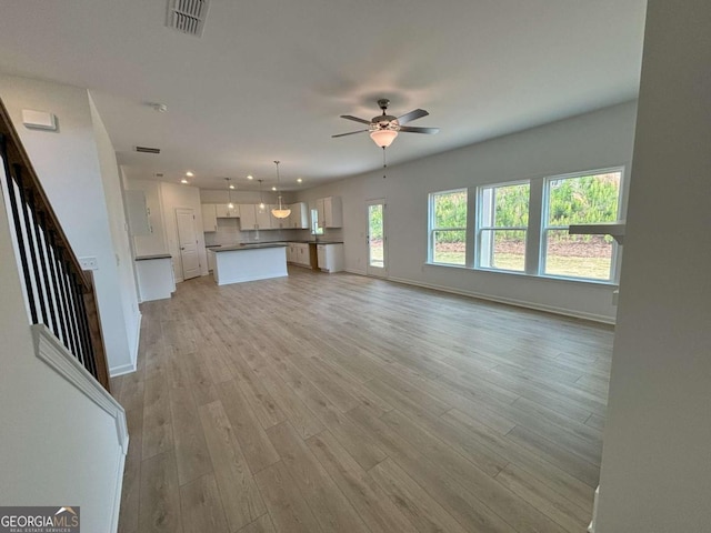 unfurnished living room featuring visible vents, baseboards, recessed lighting, light wood-style floors, and ceiling fan