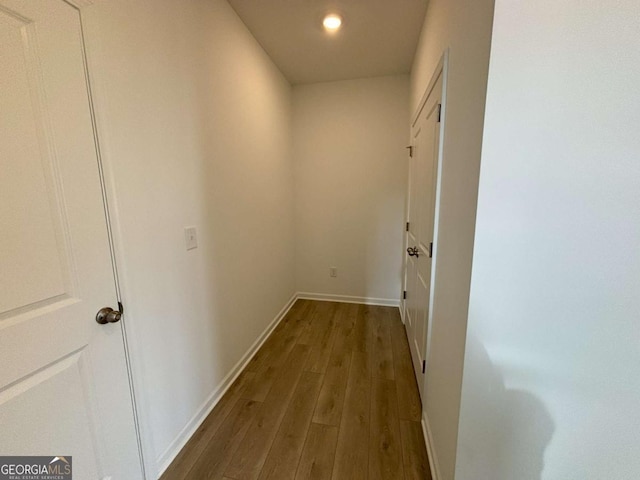 hallway featuring recessed lighting, wood finished floors, and baseboards