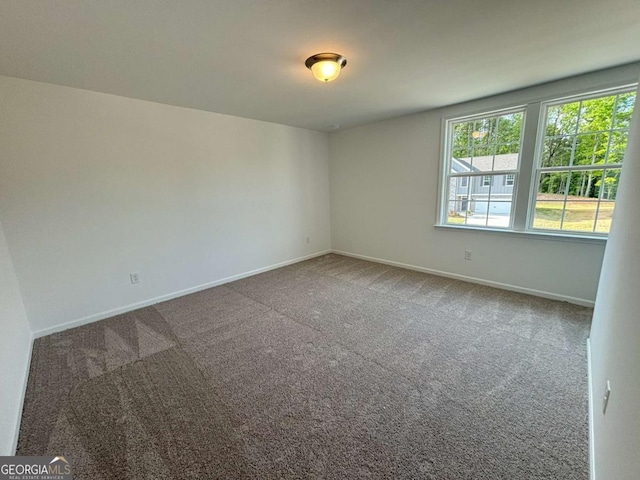 spare room featuring baseboards and carpet