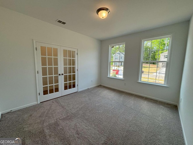 spare room featuring visible vents, carpet flooring, baseboards, and french doors