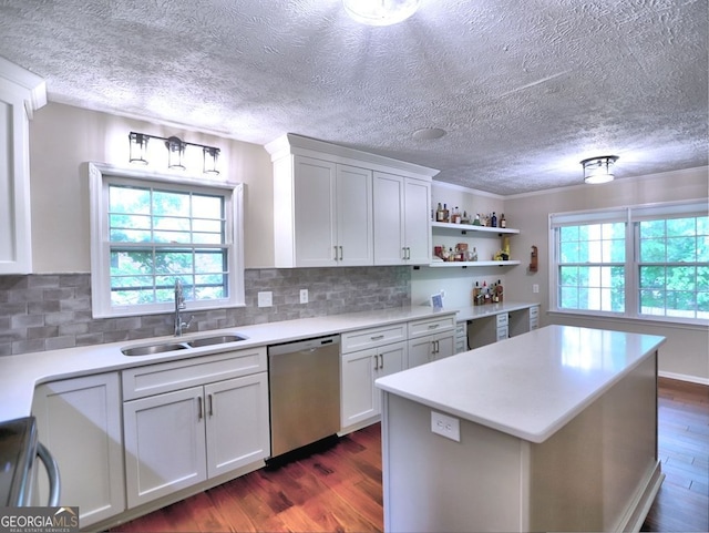 kitchen with dishwasher, a sink, dark wood-type flooring, and light countertops