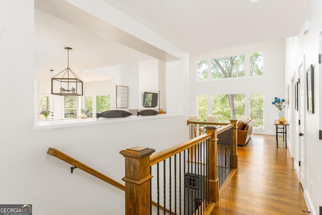 1630 Dogwood Dr, Greensboro, GA 30642 - hallway featuring an inviting chandelier, a towering ceiling, wood finished floors, and an upstairs landing