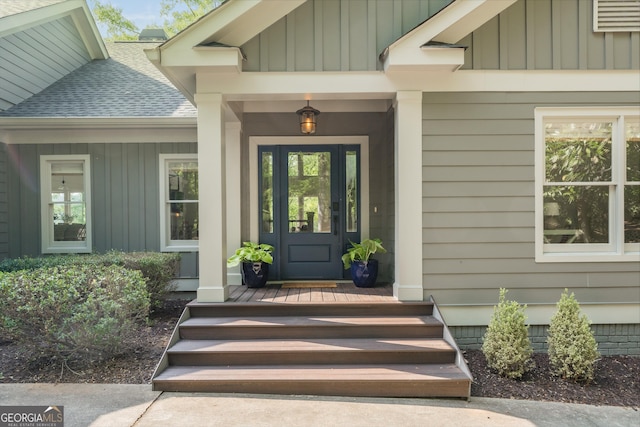 1630 Dogwood Dr, Greensboro, GA 30642 - view of exterior entry featuring board and batten siding, a shingled roof, and covered porch