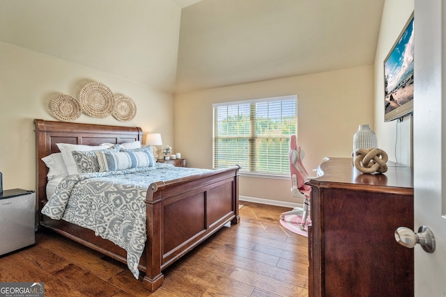 bedroom with wood finished floors, lofted ceiling, and baseboards