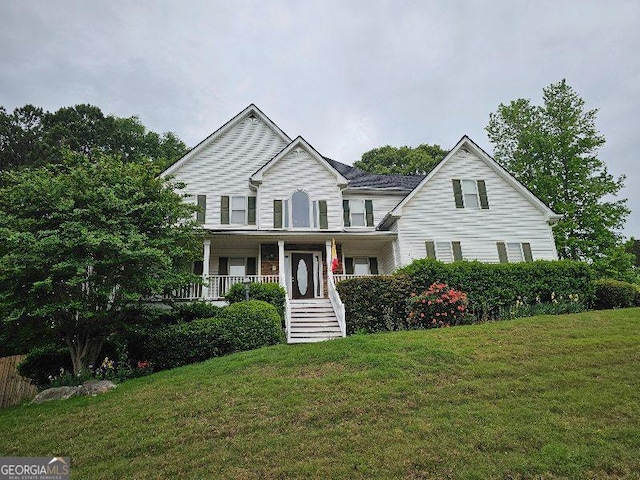 view of front of home with covered porch, a front yard, and stairway