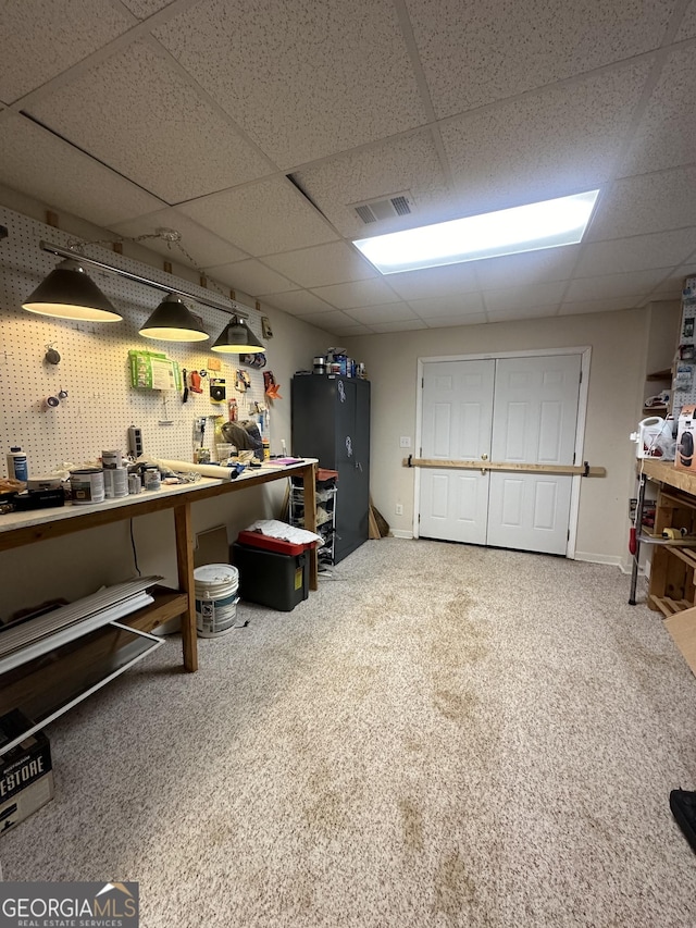 below grade area featuring a drop ceiling and carpet