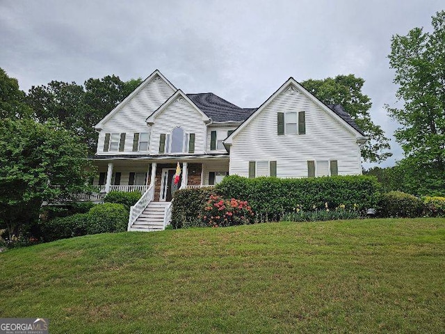 view of front of house with a porch, a front lawn, and stairs