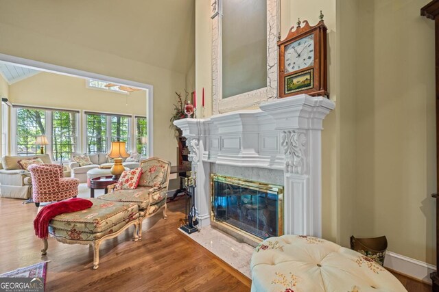 129 Barrington Hall Dr, Eatonton, GA 31024 - living room with high vaulted ceiling, a high end fireplace, baseboards, and wood finished floors