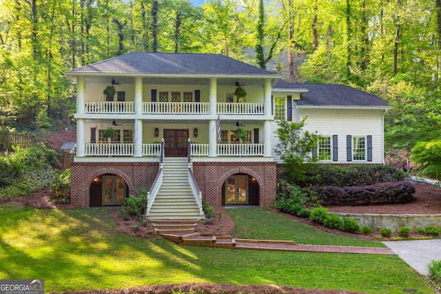 view of front of home featuring a front yard, a ceiling fan, stairs, and french doors