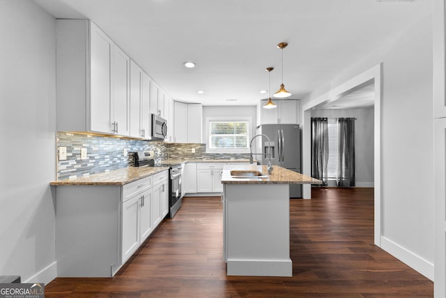 kitchen featuring backsplash, baseboards, appliances with stainless steel finishes, and light stone counters
