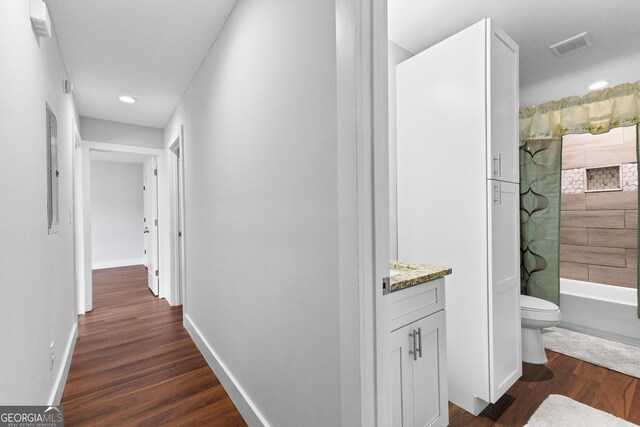 hallway featuring baseboards, dark wood-style floors, and recessed lighting