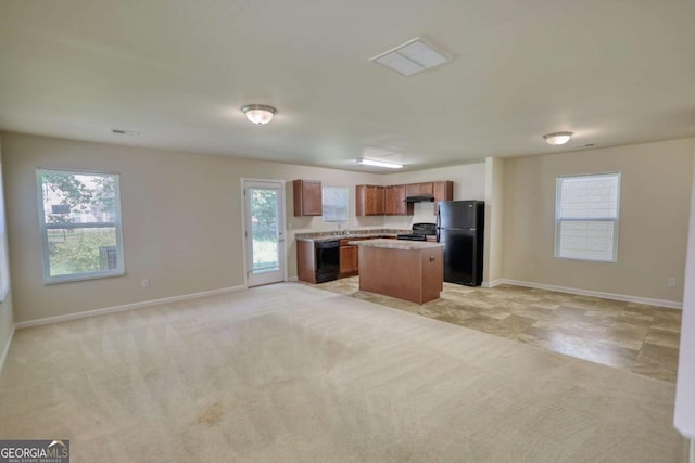 11224 Aliyah Dr, Hampton, GA 30228 - kitchen featuring a center island, open floor plan, brown cabinets, light countertops, and black appliances