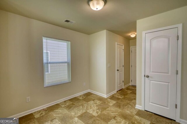 11224 Aliyah Dr, Hampton, GA 30228 - unfurnished room featuring baseboards, visible vents, and stone finish floor