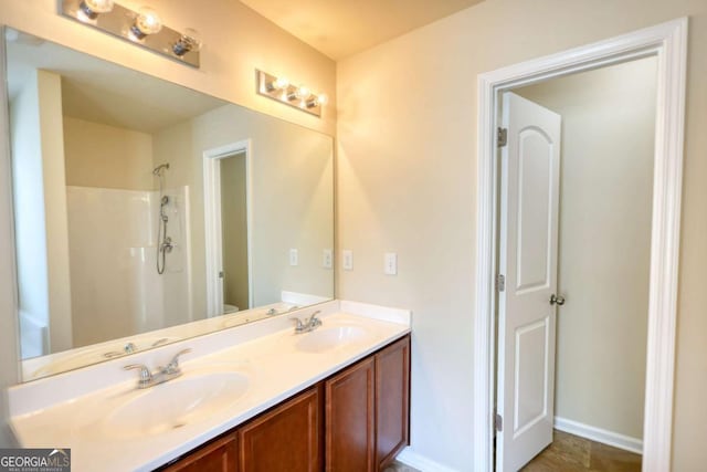11224 Aliyah Dr, Hampton, GA 30228 - bathroom featuring walk in shower, baseboards, a sink, and double vanity