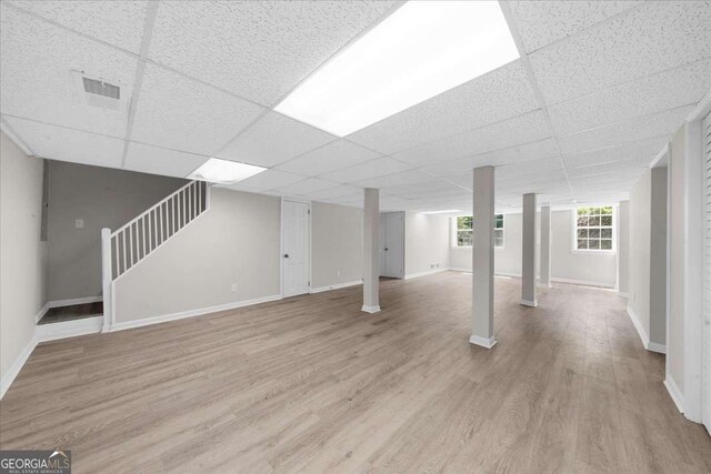 7300 Wynhill Dr, Sandy Springs, GA 30328 - basement with a paneled ceiling, stairs, light wood finished floors, and baseboards