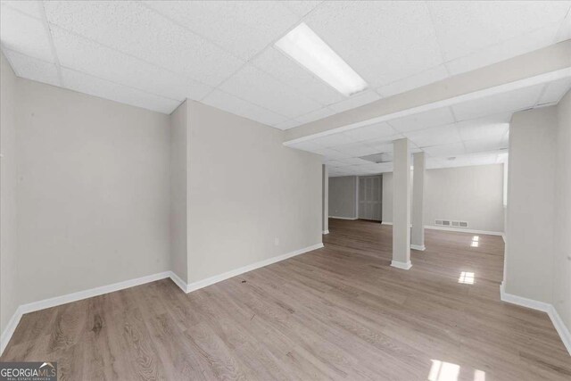 7300 Wynhill Dr, Sandy Springs, GA 30328 - finished below grade area featuring a paneled ceiling, visible vents, baseboards, and wood finished floors
