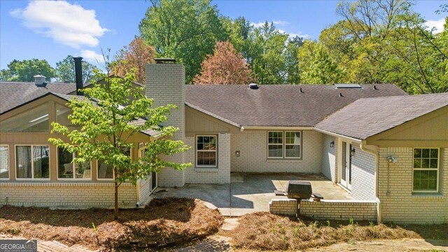 7300 Wynhill Dr, Sandy Springs, GA 30328 - rear view of property featuring a shingled roof, a chimney, brick siding, and a patio