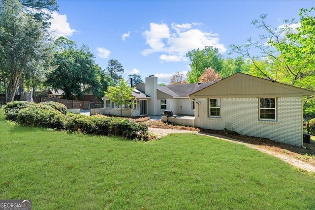 7300 Wynhill Dr, Sandy Springs, GA 30328 - rear view of property with brick siding, a yard, and a chimney