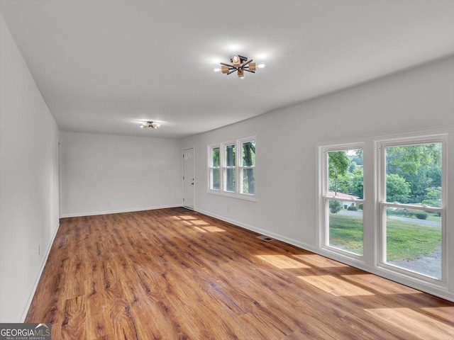 110 Dorsey St, Calhoun, GA 30701 - empty room featuring visible vents, wood finished floors, baseboards, and a notable chandelier