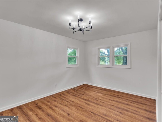110 Dorsey St, Calhoun, GA 30701 - empty room with an inviting chandelier, baseboards, and wood finished floors