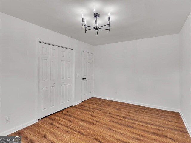 110 Dorsey St, Calhoun, GA 30701 - unfurnished bedroom featuring a chandelier, baseboards, a closet, and wood finished floors
