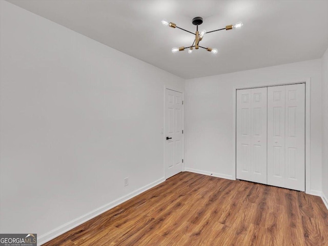 110 Dorsey St, Calhoun, GA 30701 - unfurnished bedroom featuring an inviting chandelier, baseboards, a closet, and wood finished floors