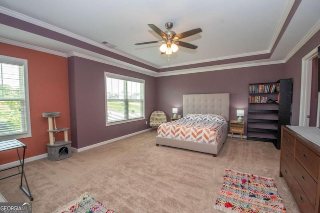 bedroom featuring light carpet, ornamental molding, a tray ceiling, and baseboards