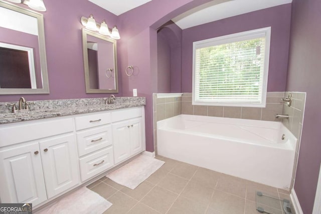 bathroom with a bath, tile patterned floors, a sink, and double vanity