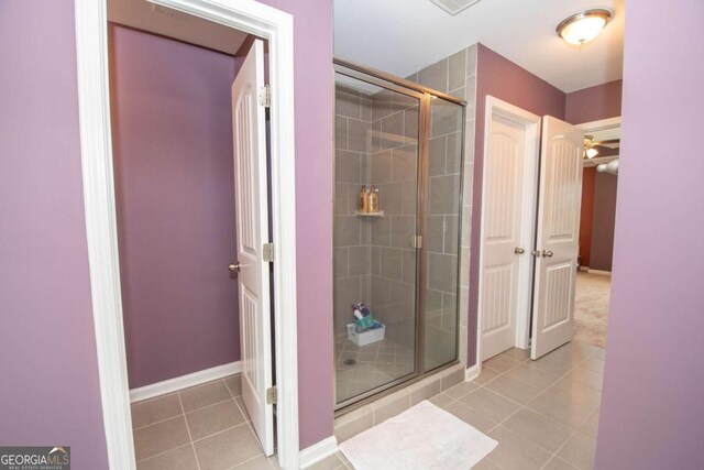bathroom with tile patterned floors, baseboards, and a stall shower