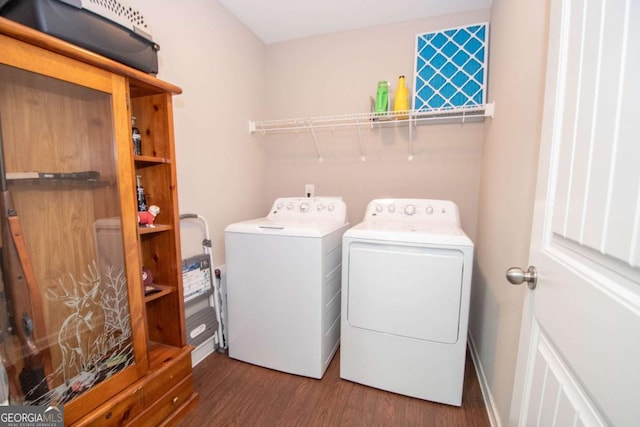 clothes washing area with washing machine and dryer, wood finished floors, baseboards, and laundry area