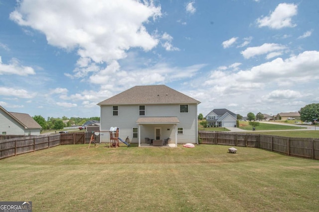 back of property with a lawn, a fenced backyard, and a playground