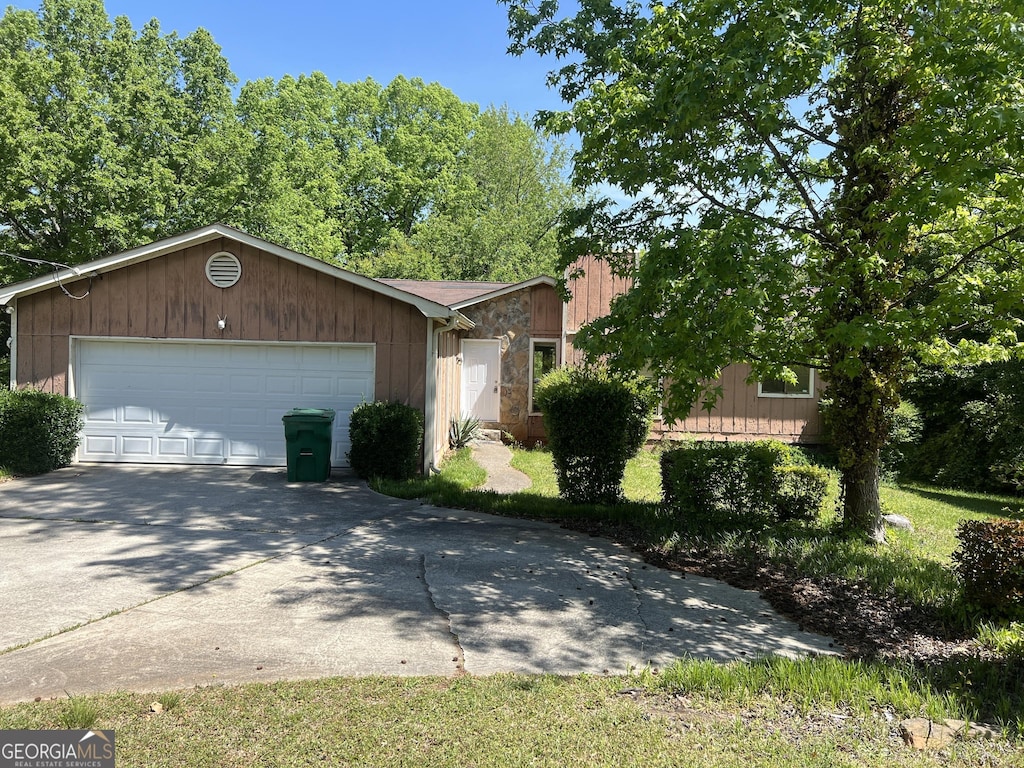 1937 Young Rd, Lithonia, GA 30058 - view of front facade with driveway, stone siding, and an attached garage