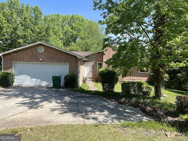 1937 Young Rd, Lithonia, GA 30058 - view of front facade with driveway, stone siding, and an attached garage