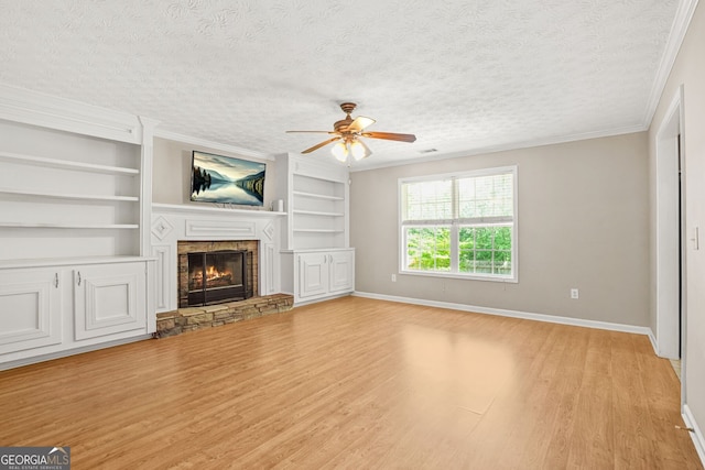 unfurnished living room featuring ornamental molding, baseboards, a stone fireplace, ceiling fan, and light wood finished floors