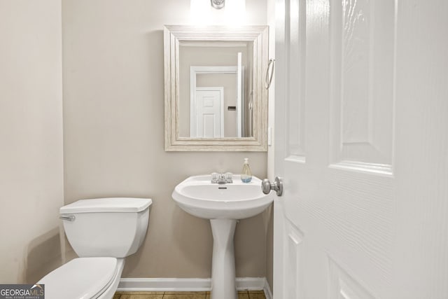 bathroom with baseboards, a sink, tile patterned floors, and toilet
