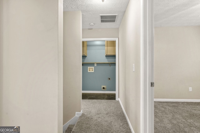 hall featuring visible vents, carpet flooring, a textured ceiling, and baseboards