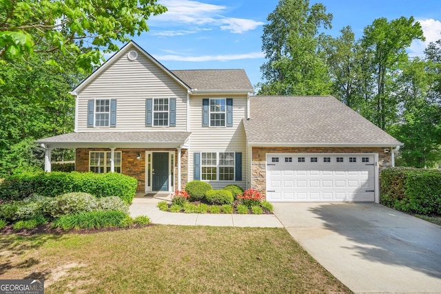 view of front of home with stone siding, an attached garage, driveway, and a front yard