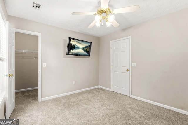 unfurnished bedroom with visible vents, carpet floors, baseboards, a spacious closet, and a closet