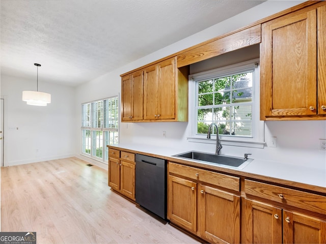 kitchen with dishwasher, a sink, light wood finished floors, brown cabinetry, and light countertops