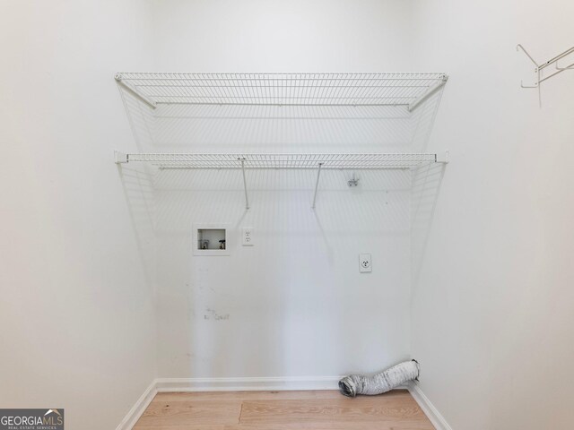 laundry area featuring electric dryer hookup, light wood-style floors, hookup for a washing machine, and baseboards