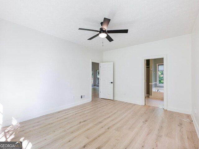 unfurnished bedroom with light wood-style floors, baseboards, connected bathroom, and ceiling fan