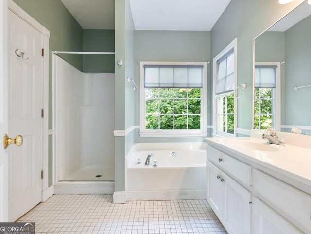 bathroom featuring a stall shower, vanity, a garden tub, tile patterned flooring, and healthy amount of natural light