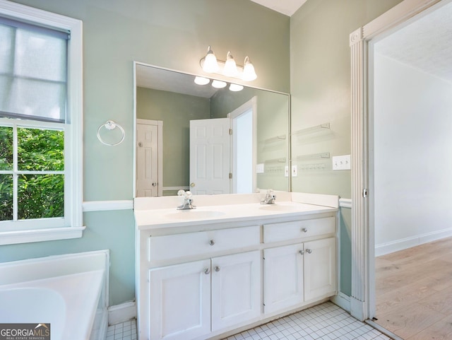 bathroom featuring double vanity, a tub, baseboards, and tile patterned flooring