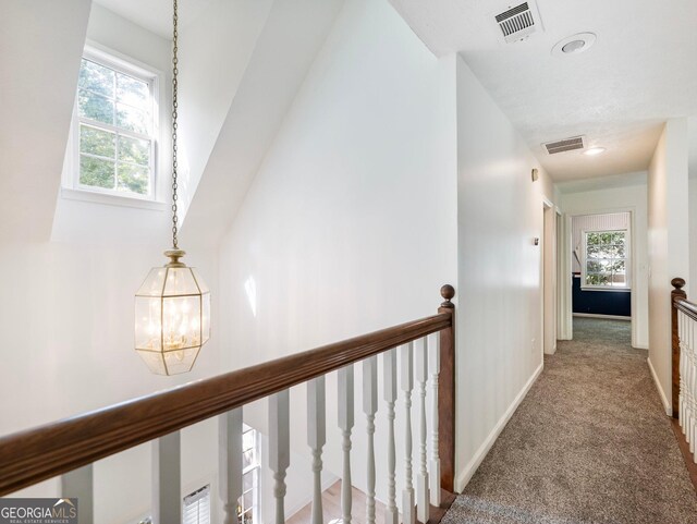 hall featuring an upstairs landing, plenty of natural light, carpet floors, a chandelier, and recessed lighting