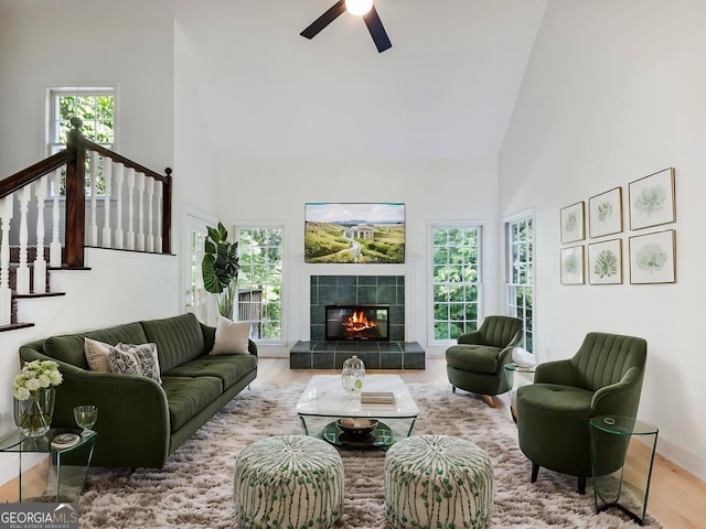 6212 Germantown Dr, Flowery Branch, GA 30542 - living room with high vaulted ceiling, wood finished floors, a ceiling fan, healthy amount of natural light, and a tiled fireplace