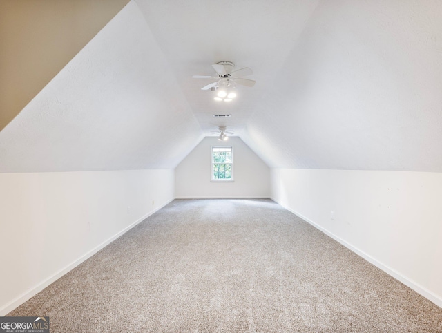 additional living space with lofted ceiling, carpet, a ceiling fan, and baseboards