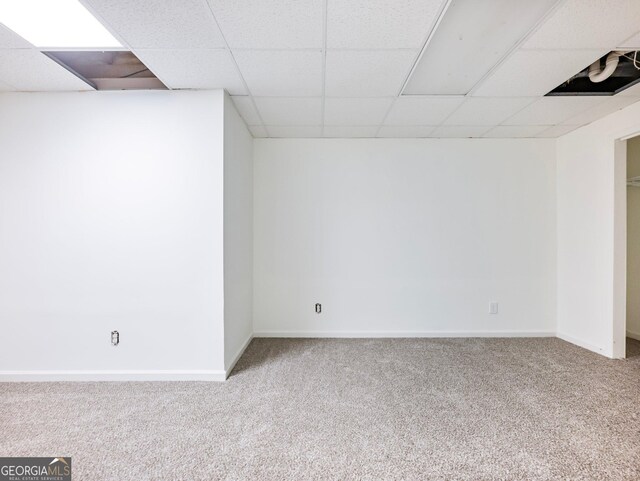 finished basement with carpet, a drop ceiling, and baseboards