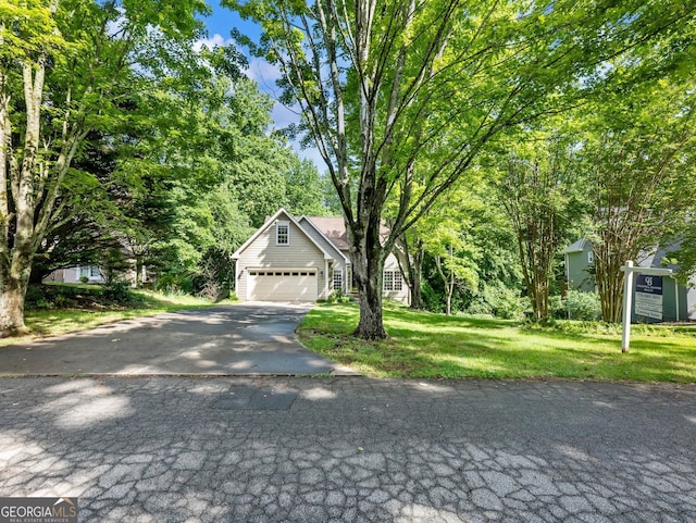 obstructed view of property featuring driveway, a front lawn, and an attached garage